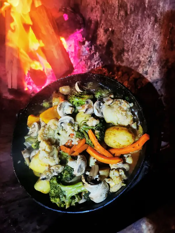 Potjiekos with vegetables and potatoes in a cast-iron pot over the fire